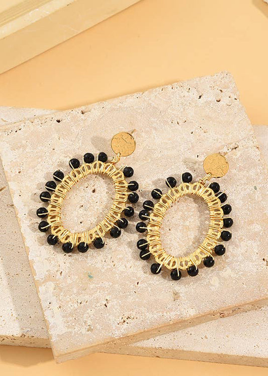 Pendientes ovalados dorados tejidos en piedras negras