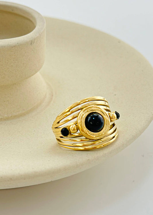 Anillo dorado multilínea con piedra negra