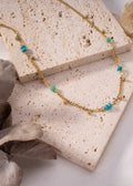 Colar de ouro com pequenas pérolas azuis